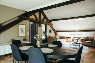 a living room with a table and chairs at La Terrasse du Pré by WelcHome in Verviers