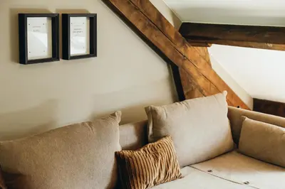a couch with two pillows in a living room at La Terrasse du Pré by WelcHome in Verviers