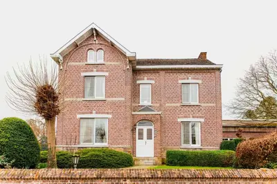 a red brick house with a white door at Beautiful mansion with swimming pool and jacuzzi in Bilzen