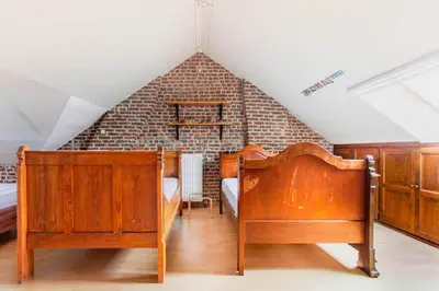 a bedroom with two beds and a brick wall at Beautiful mansion with swimming pool and jacuzzi in Bilzen
