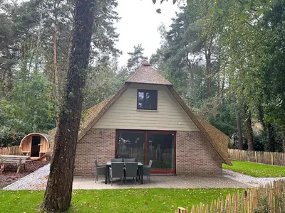 a building with tables and chairs in a yard at Vakantiewoning Waag in Rekem