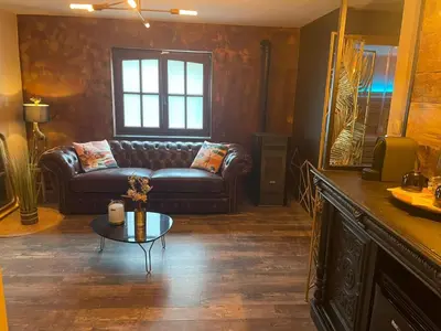 a living room with a leather couch and a table at Au coeur du 11 in Beyne-Heusay