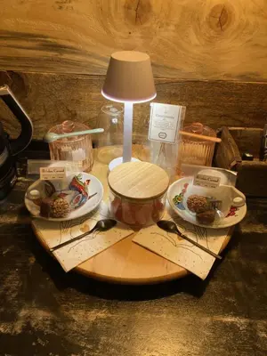 a table with a lamp and some food on a cutting board at Au coeur du 11 in Beyne-Heusay