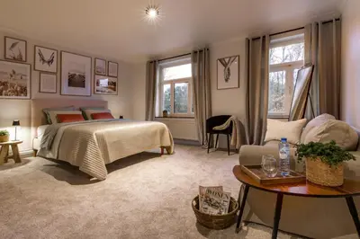 a bedroom with a bed and a couch and a table at Vakantiewoning 'De Teut' in Zonhoven