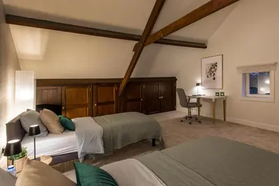a bedroom with two beds and a desk in it at Vakantiewoning 'De Teut' in Zonhoven