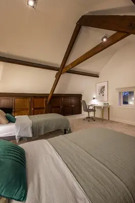a bedroom with two beds and a desk with a chair at Vakantiewoning 'De Teut' in Zonhoven