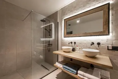 a bathroom with a shower and two sinks and a mirror at Vakantiewoning 'De Teut' in Zonhoven
