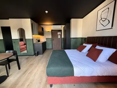 a bedroom with a bed and a table and a kitchen at Getaway Liège in Liège