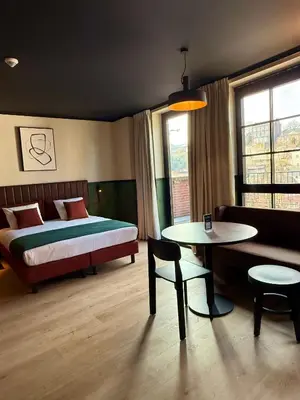 a hotel room with a bed and a table and a table sidx sidx sidx at Getaway Liège in Liège