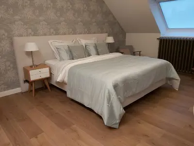 a bedroom with a large bed with a white bedspread at B&B Asmara in Maasmechelen