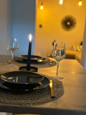 a table with plates and glasses and a candle on it at Suite Marie in Verviers