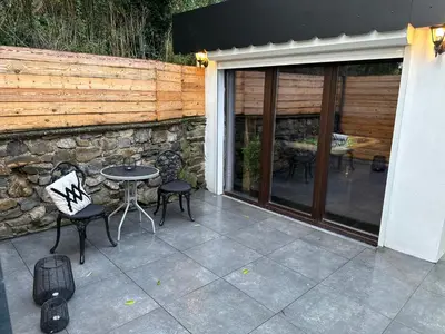 a patio with a table and chairs and a stone wall at Suite Marie in Verviers