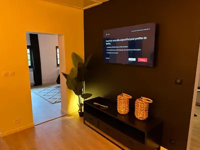 a living room with a flat screen tv on a wall at Suite Marie in Verviers
