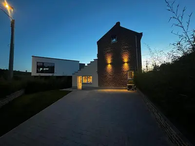 a brick building with lights on it at night at Le Gîte du Moulin - Modernity & Elegance - jacuzzi in Oupeye