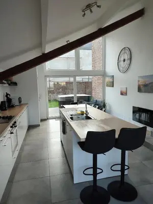 a kitchen with two bar stools and a sink at Le Gîte du Moulin - Modernity & Elegance - jacuzzi in Oupeye