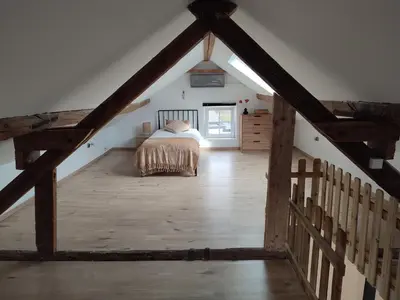 a bedroom with a bed in a attic at Le Gîte du Moulin - Modernity & Elegance - jacuzzi in Oupeye