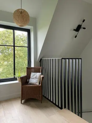 a room with a chair and a large window at Huis Hygge in Peer
