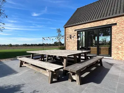 a picnic table with benches in front of a building at Huis Hygge in Peer