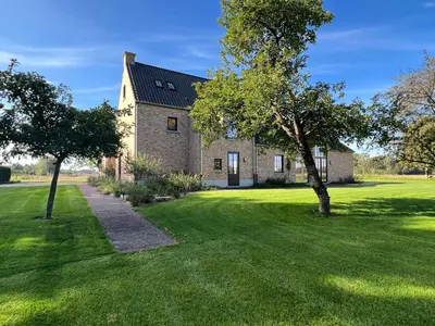 an old stone house with a tree in the yard at Huis Hygge in Peer