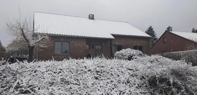 a house covered in snow in front of a house at Le Logis du Plateau in Herve
