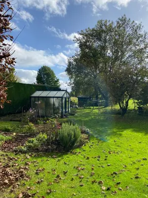 a garden with a greenhouse in a field at Le Logis du Plateau in Herve
