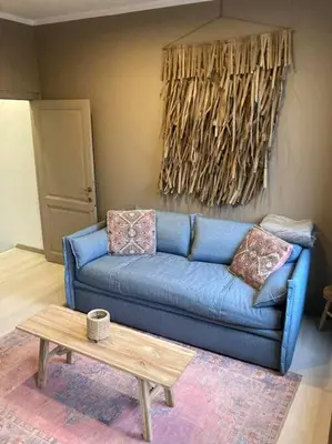 a blue couch in a living room with a coffee table at La Tour by WelcHome in Verviers