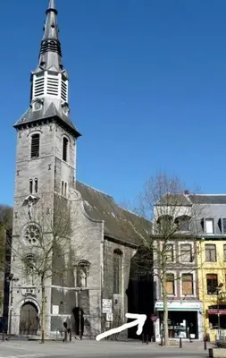 an old church with a tall steeple on a street at La Tour by WelcHome in Verviers