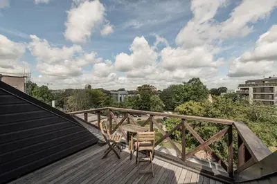 a balcony with a table and chairs on a roof at Hof van In & Wellness in Hasselt