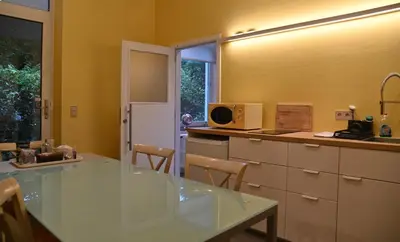 a kitchen with a glass table and a counter top at Le Chateau Blanc in Verviers