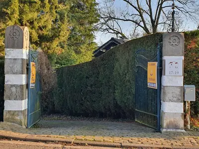 a gate to a hedge with signs on it at Le Chateau Blanc in Verviers