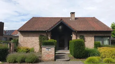 a brick house with a brown roof at Brelaarheide in Houthalen-Helchteren