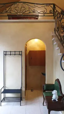 a living room with a staircase and a green chair at Brelaarheide in Houthalen-Helchteren