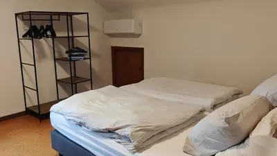 a room with two beds and a shelf with shoes at Brelaarheide in Houthalen-Helchteren