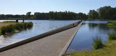 a bridge over a body of water with people on it at Brelaarheide in Houthalen-Helchteren