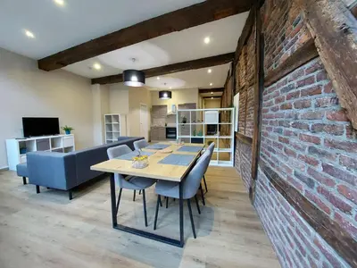 a dining room with a brick wall and a table and chairs at The Mind Box 2 in Liège