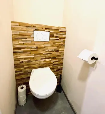 a bathroom with a toilet and a wooden wall at The Mind Box 2 in Liège