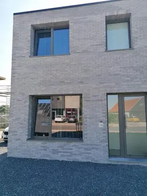 a brick building with large windows on it at Rent & Relax: Vitrabelle in Lommel