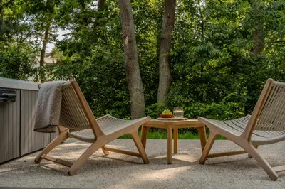 two chairs and a coffee table on a patio at Woodz Lodges in Heusden - Zolder