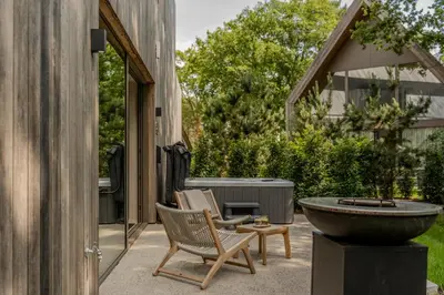 a patio with two chairs and a water fountain at Woodz Lodges in Heusden - Zolder
