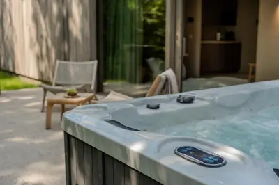 a jacuzzi tub on a patio with a chair at Woodz Lodges in Heusden - Zolder