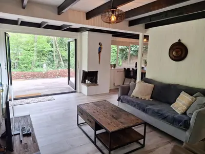 a living room with a couch and a table at Vrijstaande vakantiebungalow met optimale privacy!! in Rekem