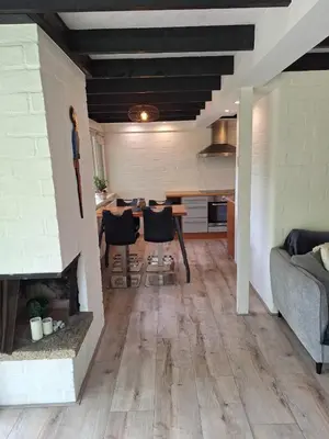 a living room with a couch and a dining room at Vrijstaande vakantiebungalow met optimale privacy!! in Rekem