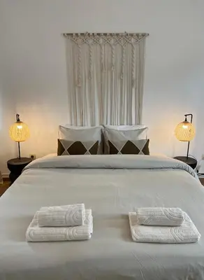 a large white bed with two towels on it at Cosy Alba plein centre Visé in Visé