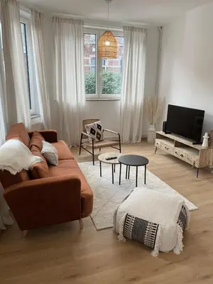 a living room with a brown couch and a tv at Cosy Alba plein centre Visé in Visé