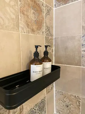 two bottles of soap on a shelf in a bathroom at Cosy Alba plein centre Visé in Visé