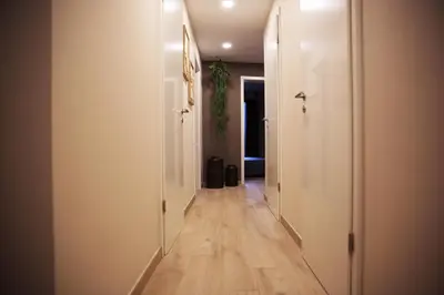 a hallway with white walls and wooden floors at L'appart Baobab, avec sauna in Liège