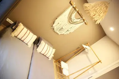 a bedroom with a bed with white pillows and a mirror at L'appart Baobab, avec sauna in Liège