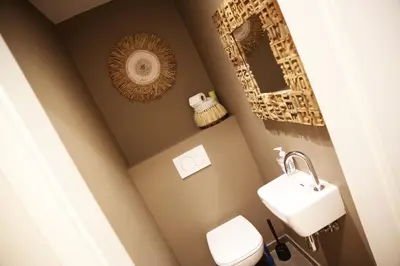 a bathroom with a white toilet and a sink at L'appart Baobab, avec sauna in Liège