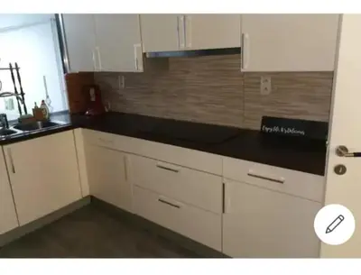 a kitchen with white cabinets and a black counter top at Vintage house ViVa in Leopoldsburg