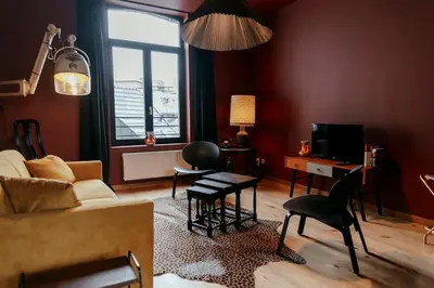 a living room with a couch and a table at Le rétro chic - Grand Duplex pour 6 dans le centre in Liège